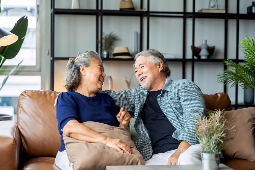 senior couple laughing on a couch for a story on how Matrix telehealth visits help with chronic care management