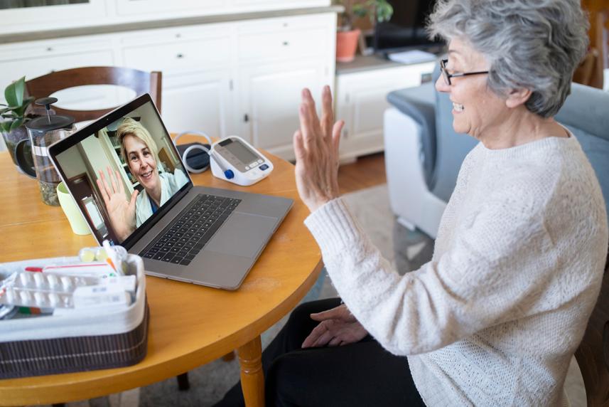senior woman waving to doctor during a telehealth visit for a story on Matrix telehealth vs. in-home assessments